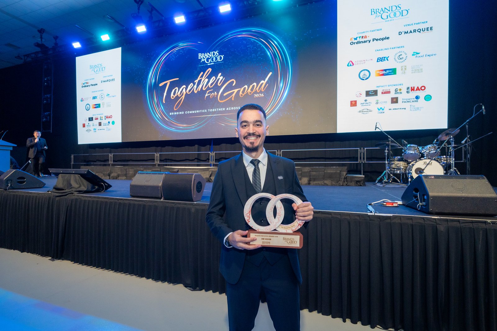 Omar Walid on stage in front of Together for Good screen